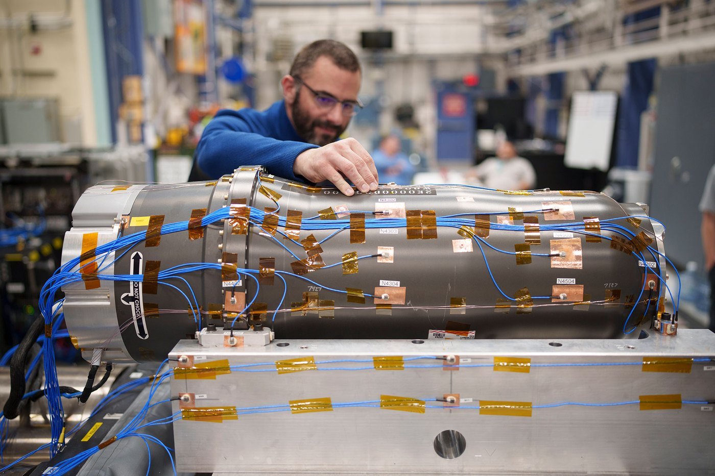 Kevin Cross placing accelerometers on an instrumented test article before a shaker table test at Sandia National Laboratories